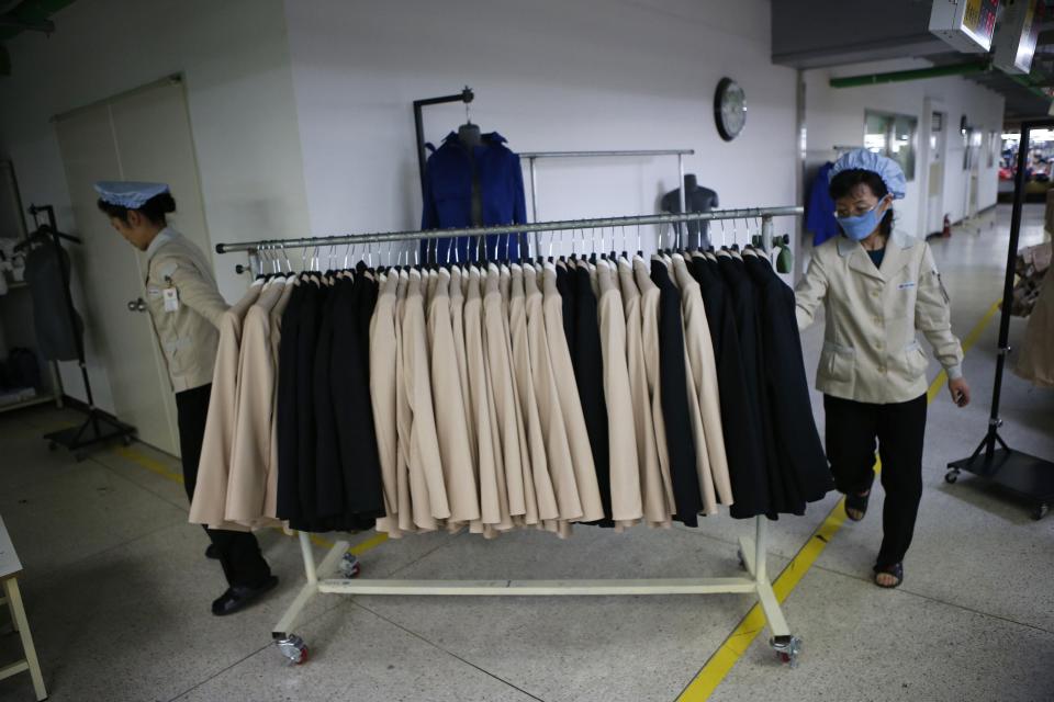 North Korean employees transport a rack of finished products in a factory of a South Korean company at the Joint Industrial Park in Kaesong industrial zone