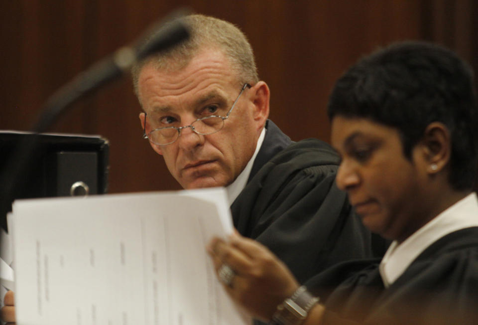 FILE In this file photo taken Thursday, March 28, 2013 state prosecutor Gerrie Nel, prepares for a hearing in the Pretoria, South Africa high court opposing the bail conditions of athlete Oscar Pistorius who is charged with the shooting death of his girlfriend Reeva Steenkamp. At the start of Pistorius' trial Monday March 3, 2014, prosecutors pressing the murder charge have listed 107 witnesses they're able to call and some will say that the world-famous athlete had a fight with Steenkamp and then intentionally killed her. (AP Photo/Denis Farrell, File)