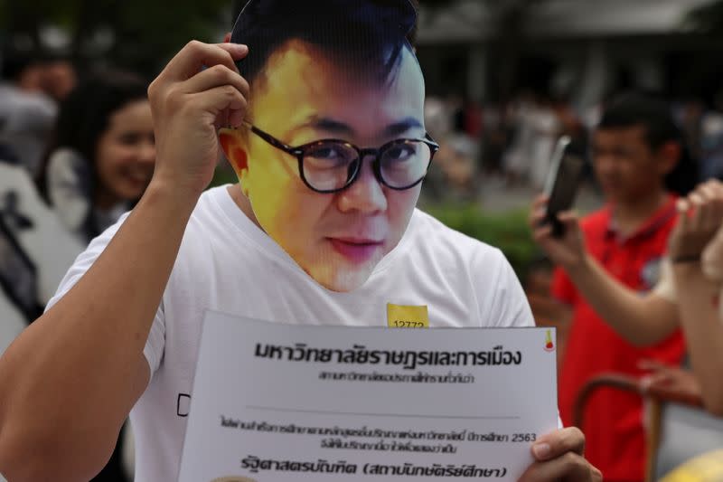 A protester holds a mask of Pavin Chachavalpongpun, an exiled Thai academic, before a graduation ceremony, which some students have boycotted because it is led by King Maha Vajiralongkorn, at Thammasat University in Bangkok