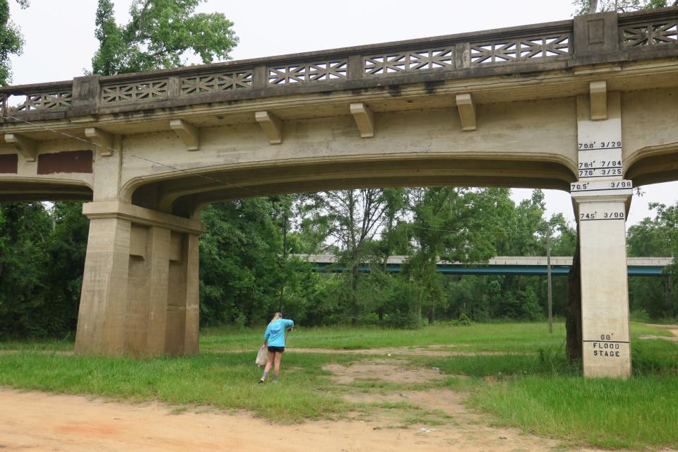 Apalachicola Riverkeeper volunteer picking up trash beneath the Victory Bridge In Chattahoochee.