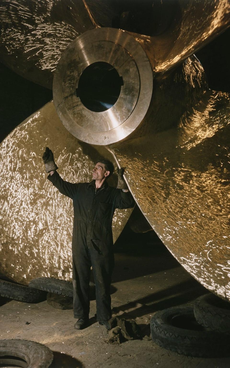 A metalworker at J Stone & Co checks the propeller for the ocean liner SS Orcades, 1947 - Westwood/Popperfoto via Getty