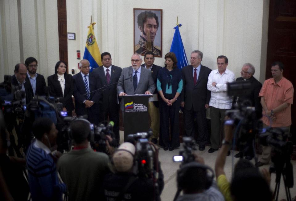 Ramon Guillermo Aveledo, center, executive secretary for the opposition Democratic Unity alliance, speaks to the media after a closed door meeting between the government and opposition representatives in Caracas, Venezuela, Tuesday, April. 15, 2014. Venezuela's opposition resumed negotiations with the government Tuesday amid rising doubts that the talks will produce a long-sought political opening. (AP Photo/Ramon Espinosa)