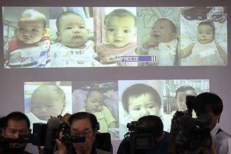 Surrogate babies that Thai police suspect were fathered by a Japanese businessman who has fled from Thailand are shown on a screen during a news conference at the headquarters of the Royal Thai Police in Bangkok August 12, 2014. REUTERS/Athit Perawongmetha