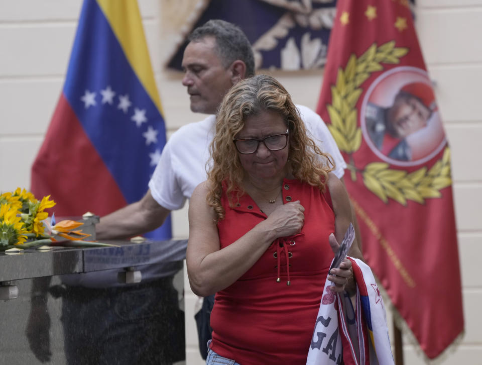 Visitors pay their respects on the tomb of late Venezuelan President Hugo Chavez during commemorations marking the tenth anniversary of his death, at the Cuartel de la Montaña 4F where his remains are interred in Caracas, Venezuela, Sunday, March 5, 2023. Chavez died on March 5, 2013, after a long battle with cancer and chose current president, Nicolas Maduro, a former bus driver and union leader to be his successor. (AP Photo/Ariana Cubillos)