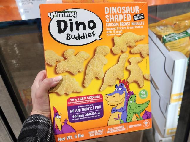 The writer holds a box of Yummy Dino Buddies