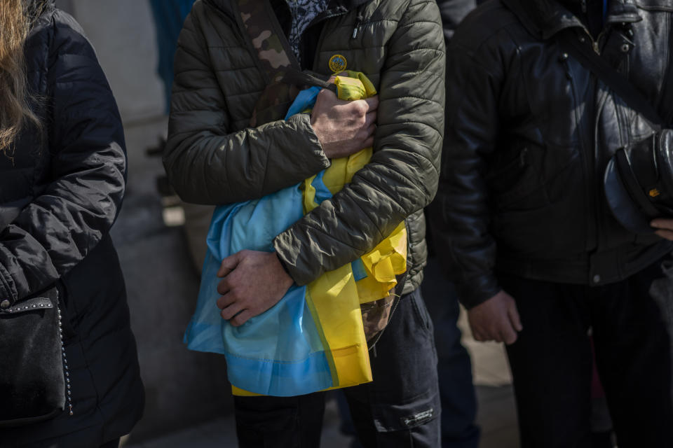 People attend a funeral ceremony for four of the Ukrainian military servicemen, who were killed during an airstrike in a military base in Yarokiv, in a church in Lviv, Ukraine, Tuesday, March 15, 2022. At least 35 people were killed and many wounded in Sunday's Russian missile strike on a military training base near Ukraine's western border with NATO member Poland. (AP Photo/Bernat Armangue)