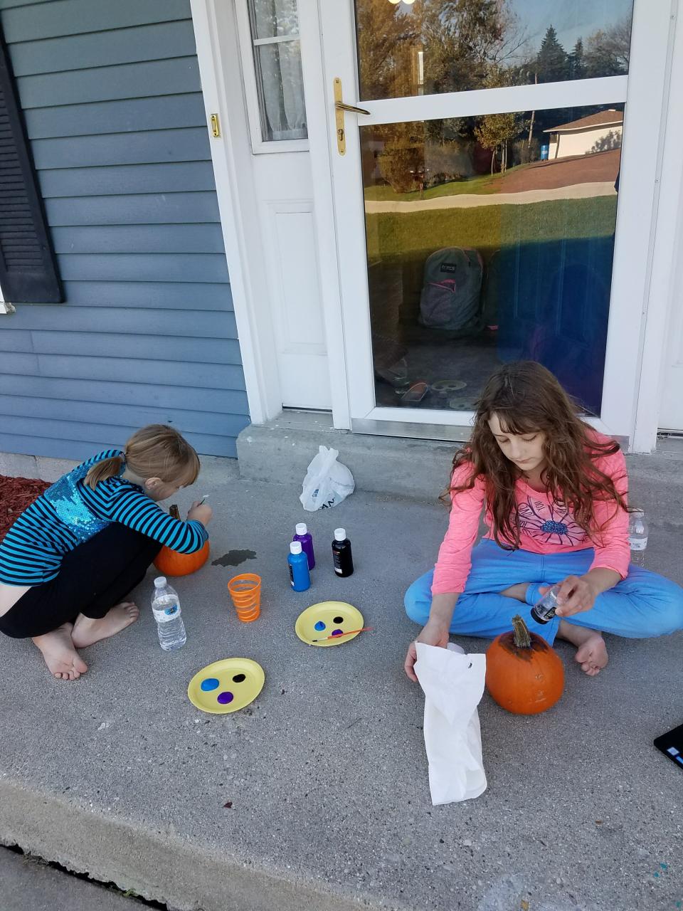 Wendy and Alex Schwabe work on painting pumpkins teal in order to participate in the Teal Pumpkin Project to include children with food allergies in trick-or-treating celebrations.