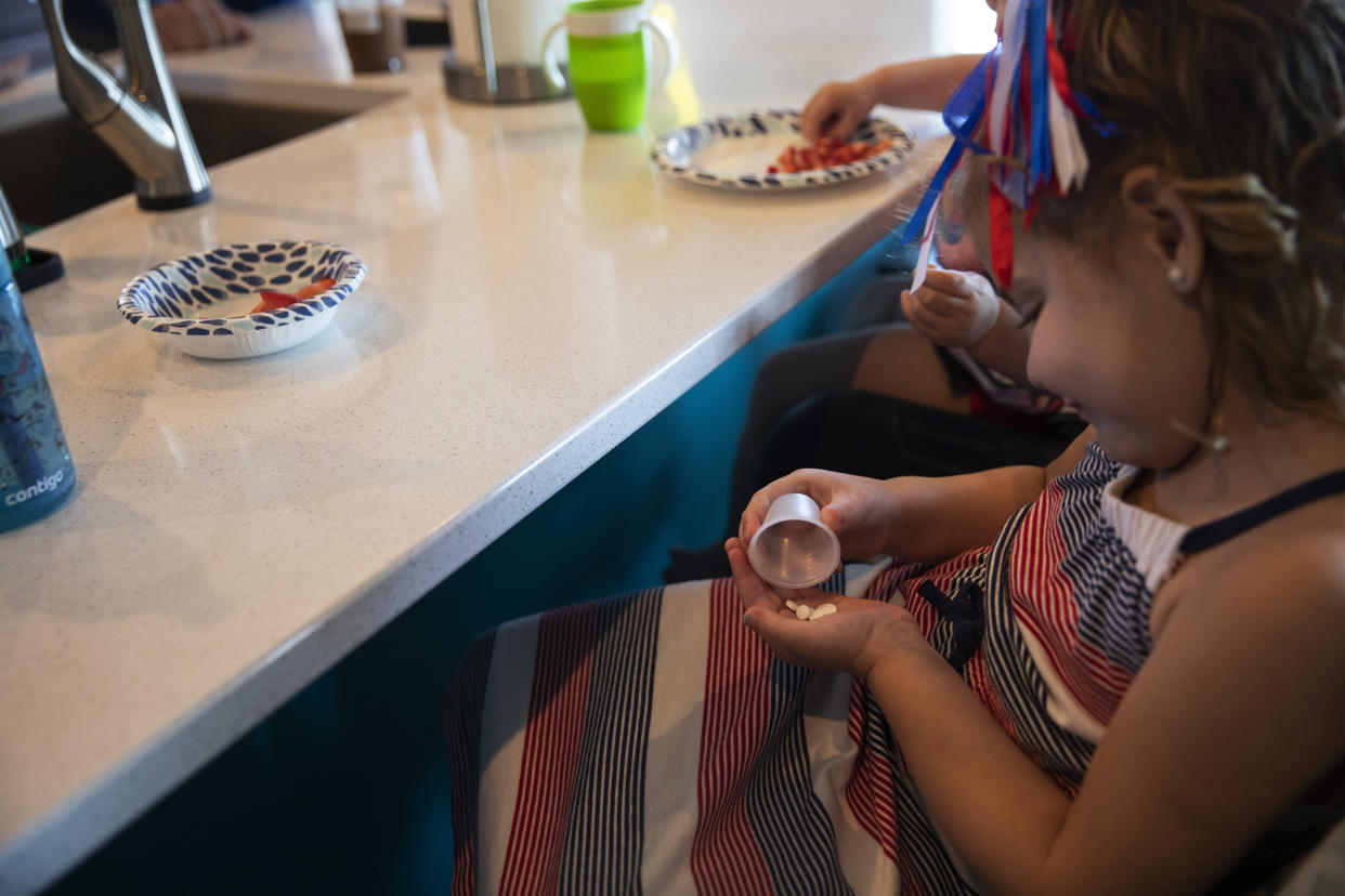 Liviah Widders, quien recibió un trasplante de hígado en enero, toma su medicamento en su casa en Mason, Ohio, el 30 de mayo de 2022. (Maddie McGarvey/The New York Times).
