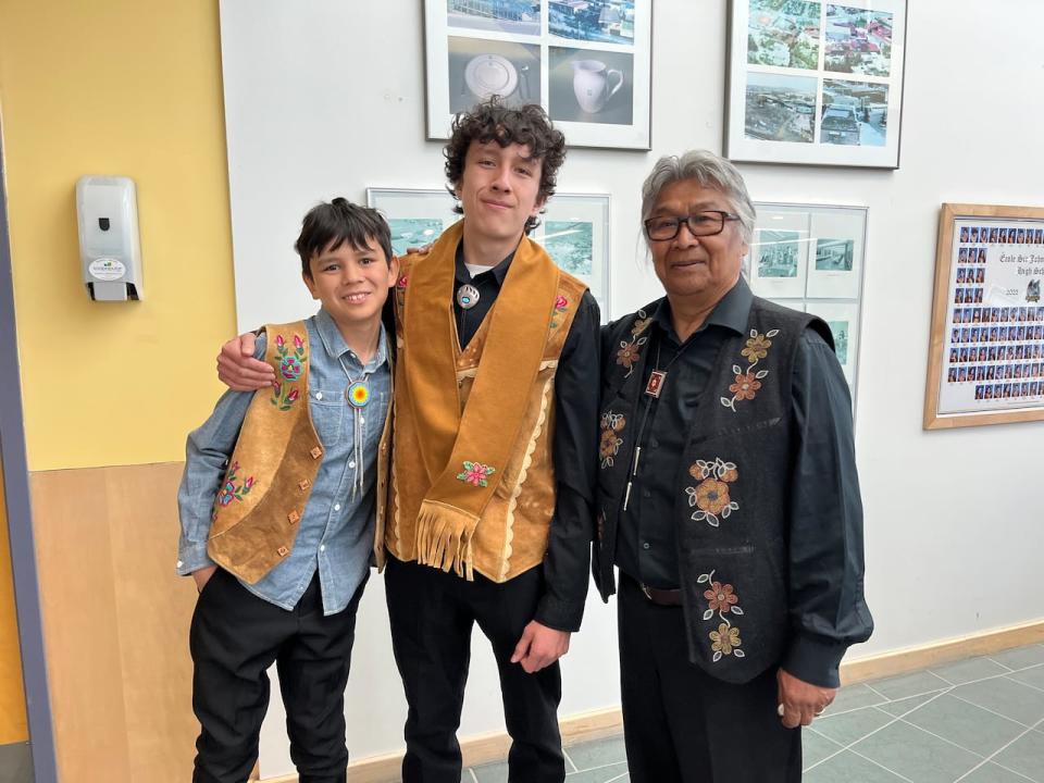 Tydzeh Kakfwi, centre, at the Indigenous Honour Ceremony for high school graduates in Yellowknife, with his brother Ry'den and grandfather Stephen Kakfwi.