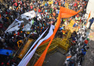 NEW DELHI, INDIA - JANUARY 26: Farmers break through barricades following a clash with Delhi Police during the tractor march from Tikri border, at Nagloi Crossing, on January 26, 2021 in New Delhi, India. Major scenes of chaos and mayhem at Delhi borders as groups of farmers allegedly broke barricades and police check posts and entered the national capital before permitted timings. Police used tear gas at Delhi's Mukarba Chowk to bring the groups under control. Clashes were also reported at ITO, Akshardham. Several rounds of talks between the government and protesting farmers have failed to resolve the impasse over the three farm laws. The kisan bodies, which have been protesting in the national capital for almost two months, demanding the repeal of three contentious farm laws have remained firm on their decision to hold a tractor rally on the occasion of Republic Day.(Photo by Raj K Raj/Hindustan Times via Getty Images)