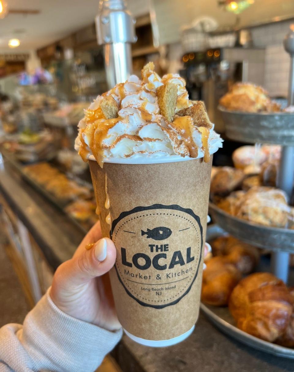A pumpkin spice latte topped with whipped cream and snickerdoodle cookies from The Local Market and Kitchen.
