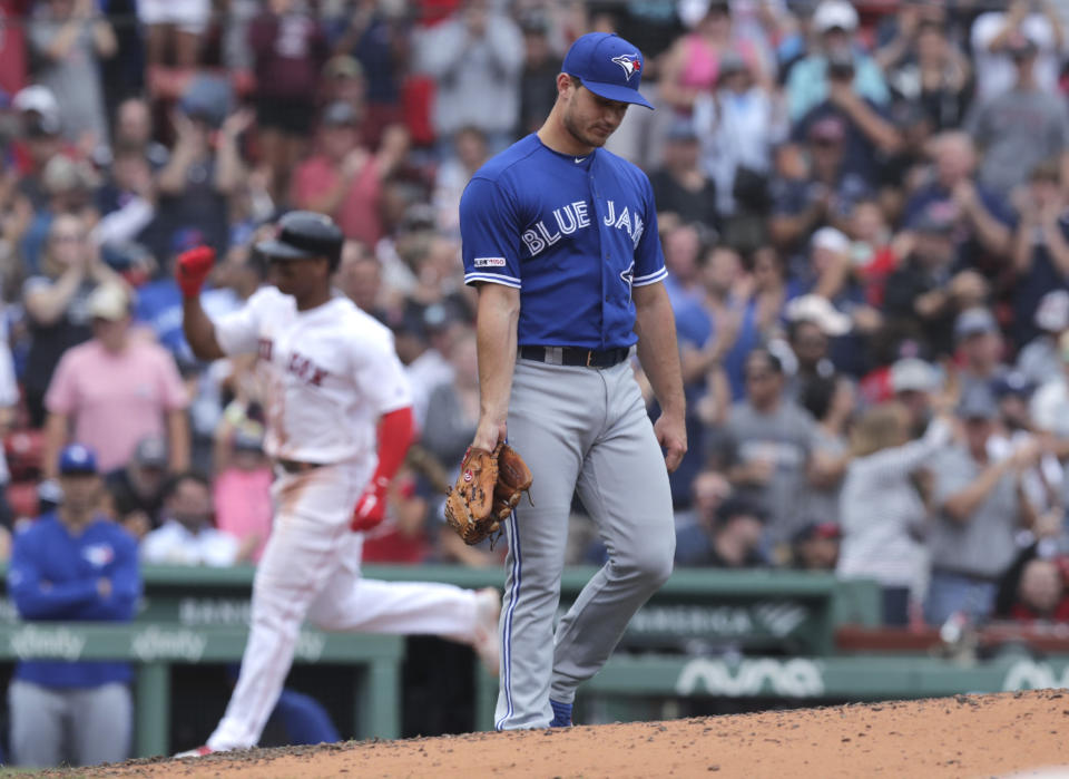 Toronto Blue Jays starting pitcher Thomas Pannone, right, walks back to the mound after giving up a three-run home run to Boston Red Sox's Rafael Devers, left, during the fifth inning of a baseball game against the Toronto Blue Jays at Fenway Park in Boston, Thursday, July 18, 2019. (AP Photo/Charles Krupa)