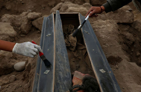 Archaeologists work at a tomb of one of sixteen Chinese migrants, discovered buried at the turn of the 20th century in the pre-colombian pyramid of Bellavista, according to Ministry of Culture, in Lima, Peru, August 24, 2017. REUTERS/Mariana Bazo