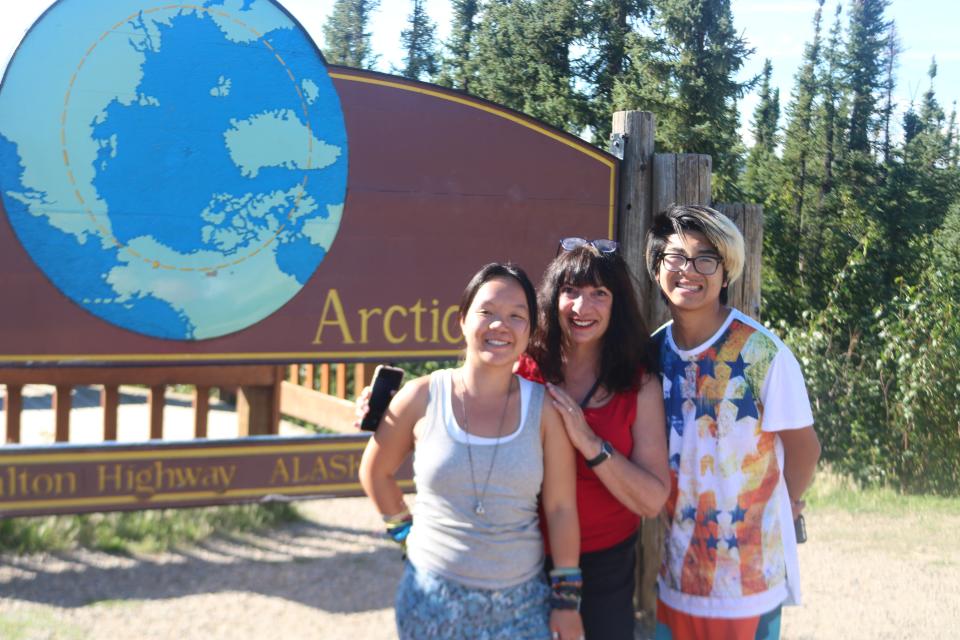 The author and her children in front of the marker for the Arctic Circle. (Photo: Courtesy of Ann Brenoff)