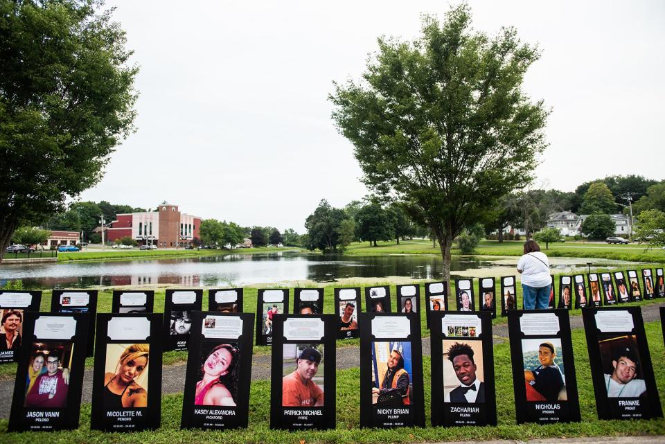 People read the stories of those remembered on posters at the Black Poster Project at Crane Park in Monroe on August 7, 2021.