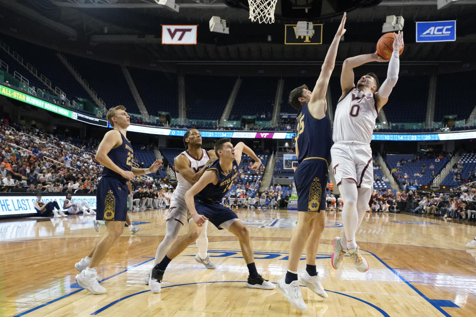 Virginia Tech guard Hunter Cattoor (0) shoots against Notre Dame forward Matt Zona (25) during the first half of an NCAA college basketball game at the Atlantic Coast Conference men's tournament in Greensboro, N.C., Tuesday, March 7, 2023. (AP Photo/Chuck Burton)