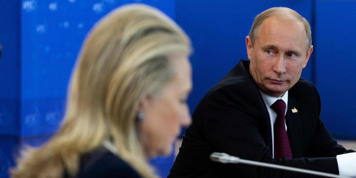 Secretary of State Hillary Clinton, foreground, looks at papers while President Vladimir Putin and Vietnam President Truong Tan Sang sit nearby, at a 2012 APEC summit.