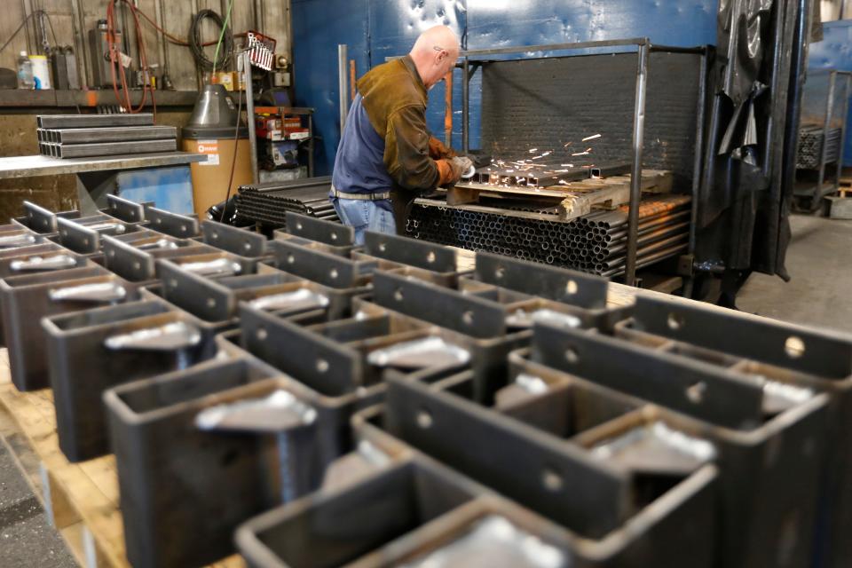 Kevin Kerby files a metal section of a boat lifting system made at the Brownell Boat Stands manufacturing plant in the Mattapoisett industrial park.