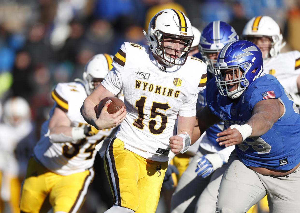 Wyoming quarterback Levi Williams, left, is tackled by Air Force defensive lineman Mosese Fifita after a short gain in the second half of an NCAA college football game Saturday, Nov. 30, 2019, at Air Force Academy, Colo. Air Force won 20-6. (AP Photo/David Zalubowski)