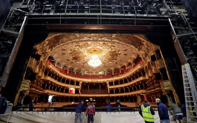 Workers install a new curtain during a general renovation of Prague's State Opera building