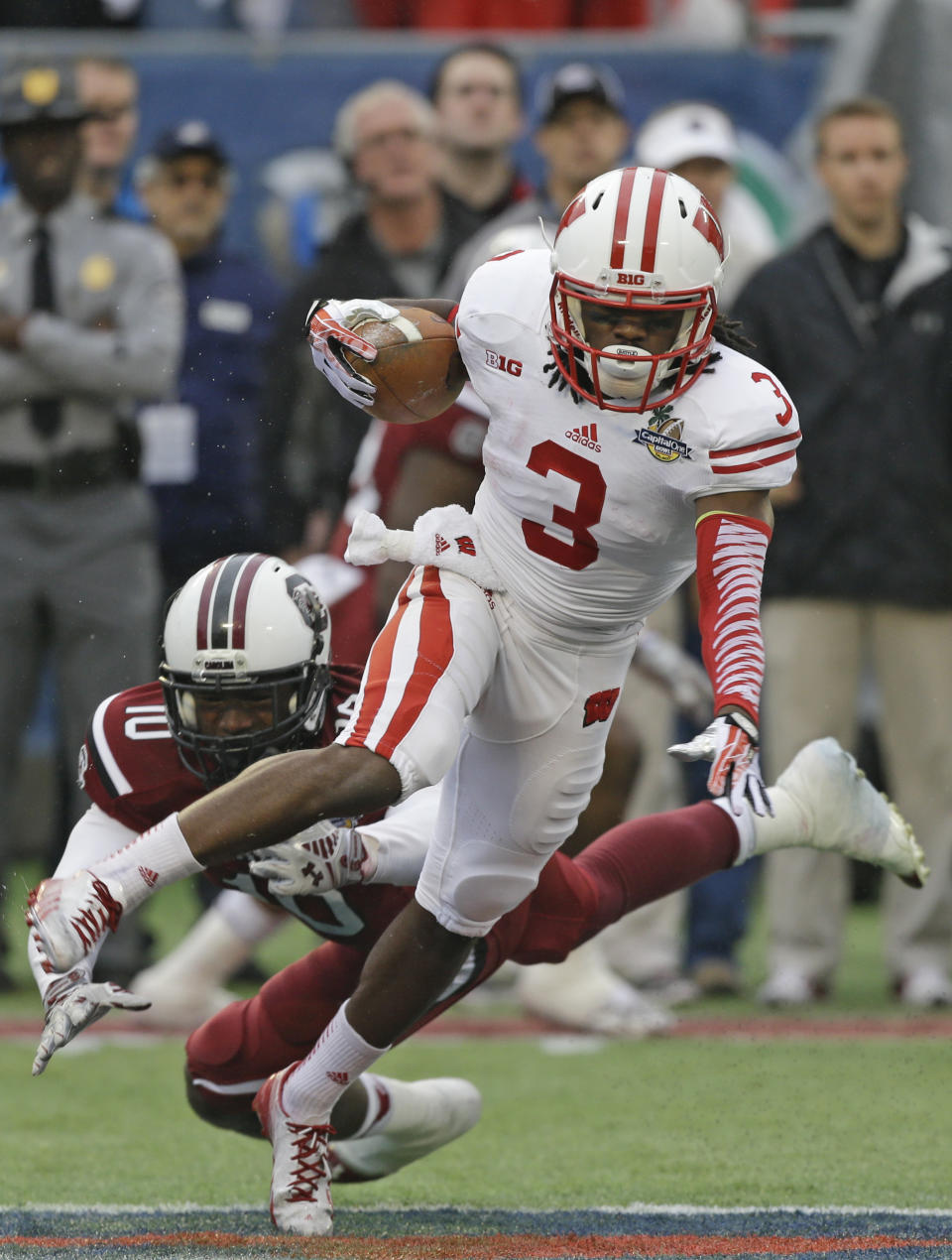 Wisconsin's Kenzel Doe (3) runs past South Carolina's Skai Moore (10) on a kickoff return during the first half of the Capital One Bowl NCAA college football game in Orlando, Fla., Wednesday, Jan. 1, 2014.(AP Photo/John Raoux)