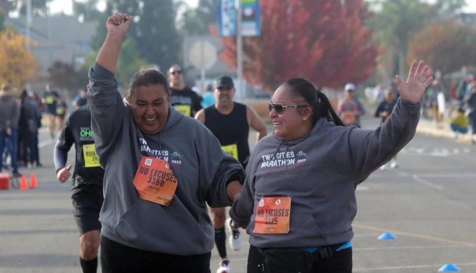 Angélica Nava, 38, of Merced, and María Pantoja León, 37, of Merced, celebrate after finishing the 10-kilometer portion of the Two Cities Half Marathon on Nov. 5, 2023.