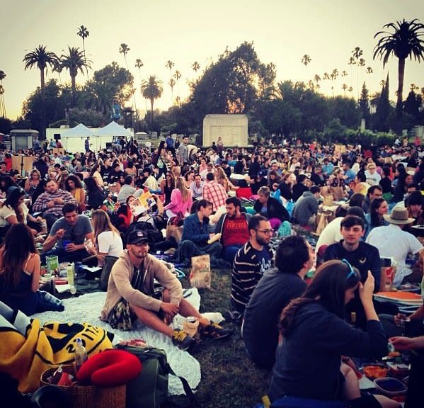 This crowd watches "The Man Who Knew Too Much" at LA's Hollywood Forever Cemetery. The attraction has long been hailed as  favorite summer activity, as crowds bring in picnics, drinks and games for the outdoor evening every Saturday night in the summer.