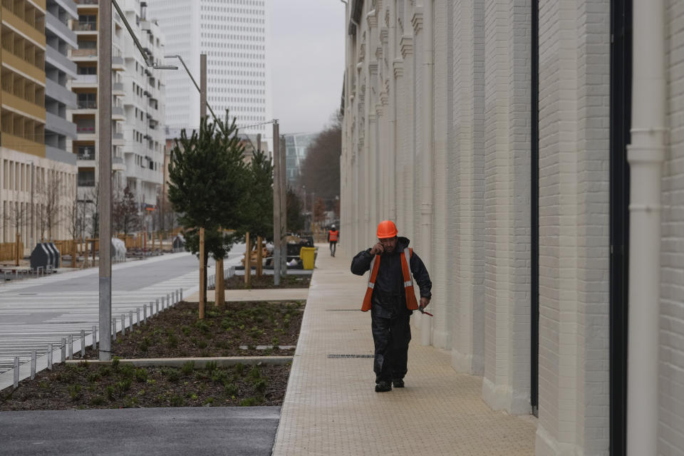 A worker walks in a street of the Olympic village, in Saint-Denis, north of Paris Wednesday, Feb. 28, 2024. When French President Emmanuel Macron inaugurates the Olympic village on Thursday, Feb. 29, he will see a run-down area transformed into an international hub for the Paris Games. (AP Photo/Thibault Camus)