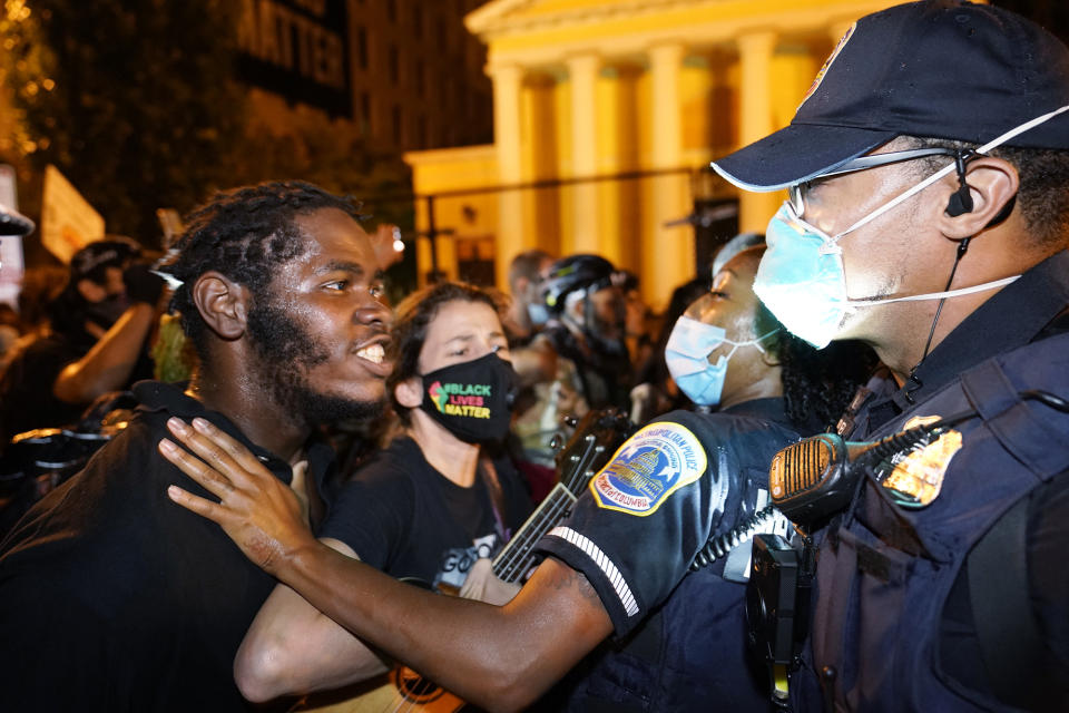 Metropolitan Police are confronted by protestors as police carry away a handcuffed protestor along a section of 16th Street, Northwest, renamed Black Lives Matter Plaza, Thursday night , Aug. 27, 2020, in Washington, after President Donald Trump had finished delivering his acceptance speech from the White House South Lawn(AP Photo/Julio Cortez)