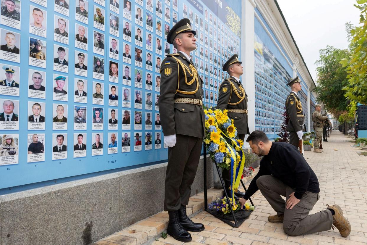 Zelensky leaves flowers at the wall (via REUTERS)