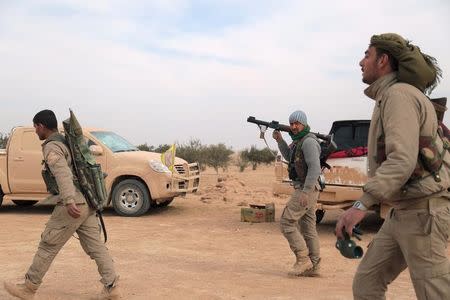 Syrian Democratic Forces (SDF) fighters walk with their weapons during an offensive against Islamic State militants in northern Raqqa province, Syria February 8, 2017. REUTERS/Rodi Said