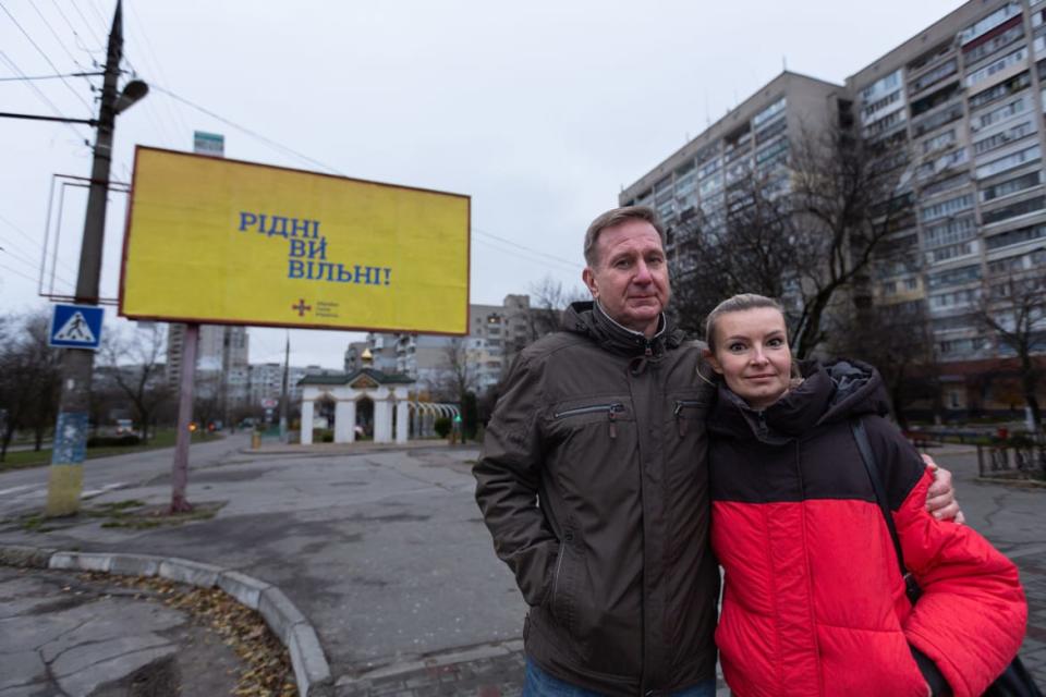 <div class="inline-image__caption"><p>Kostyantyn Babenko and Hanna Aleksandrova in front of a Ukrainian billboard in Kherson that reads “Countrymen, you are free!”</p></div> <div class="inline-image__credit">Daniel Brown</div>