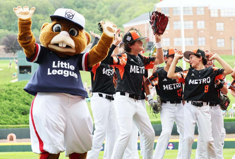 Before their game on Wednesday, Smithfield players dance with 'Dugout' at Lamade Stadium in Williamsport, Pa.