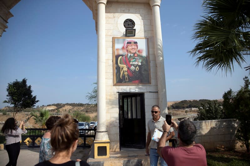 A picture of Jordan's King Abdullah is seen as people return after visiting the "Island of Peace" in an area known as Naharayim in Hebrew and Baquora in Arabic, on the Jordanian side of the border with Israel