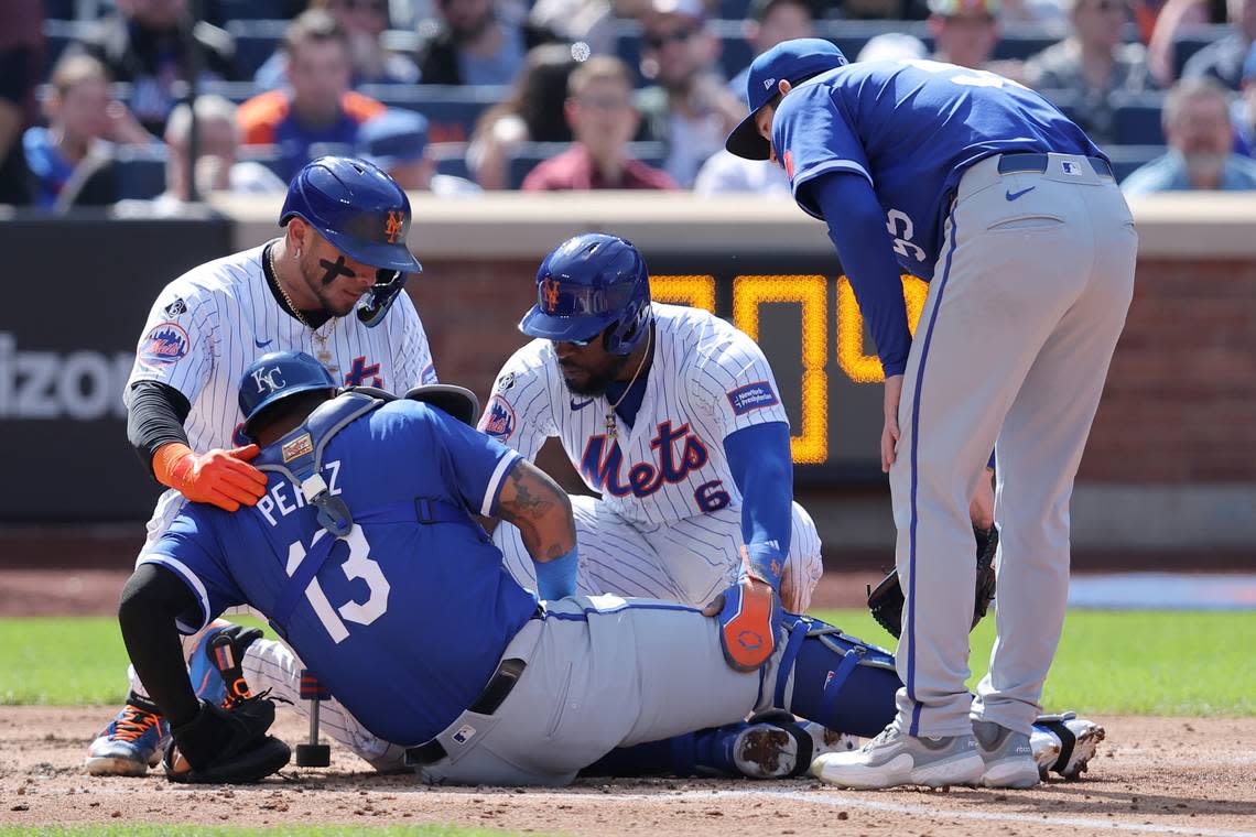 Kansas City Royals catcher Salvador Perez (13) is helped up by New York Mets catcher Francisco Alvarez and designated hitter Starling Marte as KC starting pitcher Cole Ragans looks on in the fourth inning at Citi Field.
