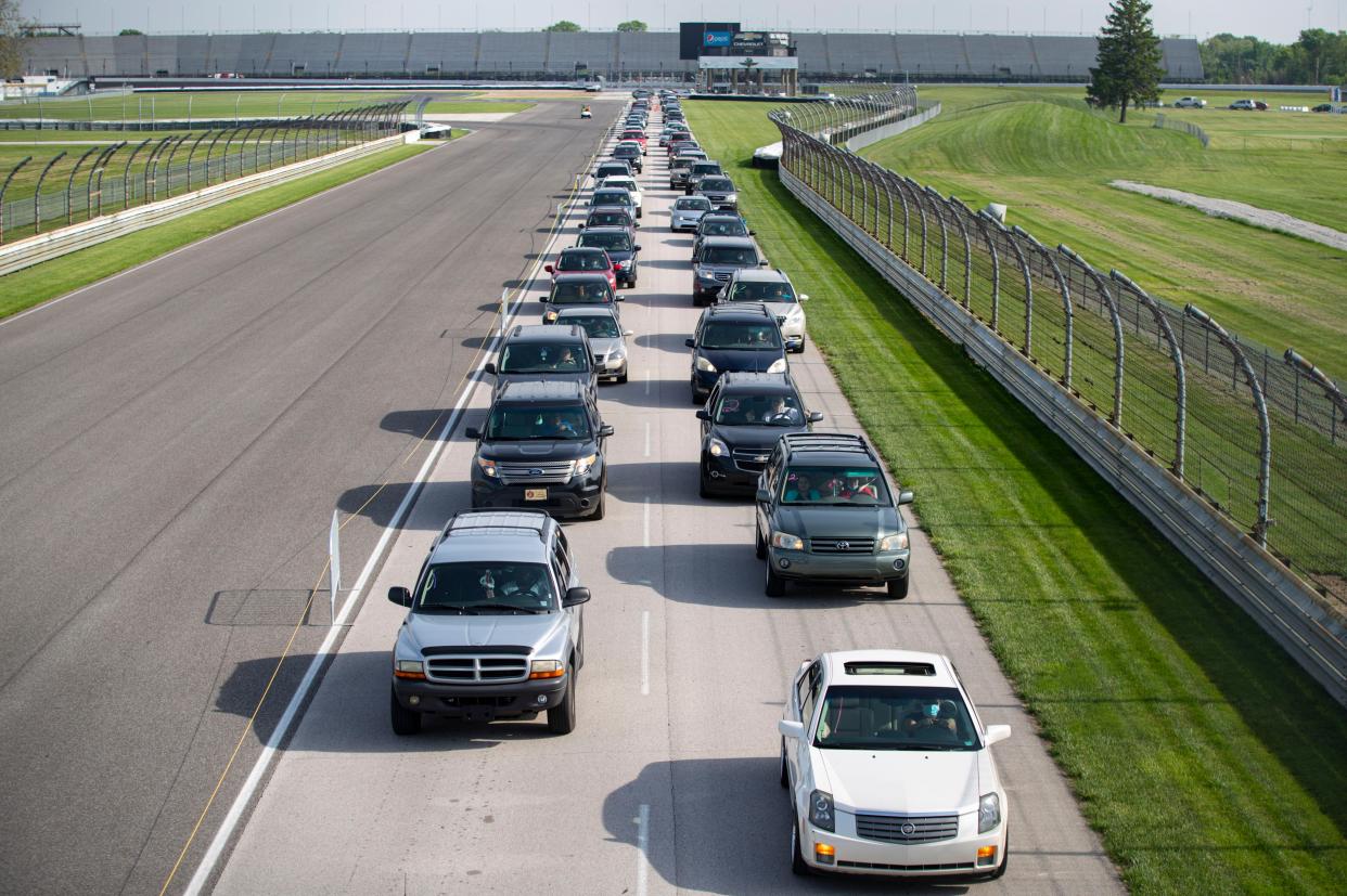 Vehicles line up in the infield of the Indianapolis Motor Speedway in Indianapolis on Saturday, May 23, 2020, for a mobile food distribution event. Gleaners Food Bank of Indiana expected to distribute boxes of fresh produce, lean meat, and dairy to more than 5,000 people at the event with the help of the Indiana National Guard. The Speedway hosted the event on what would have been the eve of the Indianapolis 500 that was postponed due to the coronavirus outbreak.