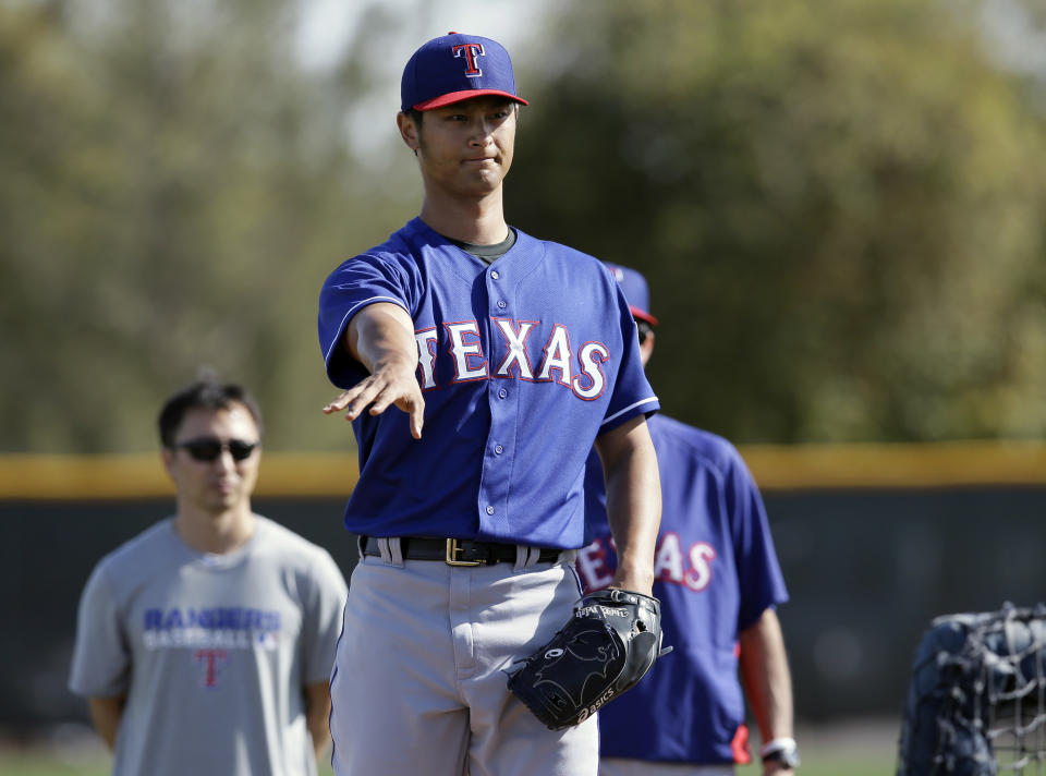 Texas Rangers' Yu Darvish, of Japan, motions with his arm after delivering a pitch in batting practice during baseballs spring training Tuesday, Feb. 18, 2014, in Surprise, Ariz. (AP Photo/Tony Gutierrez)