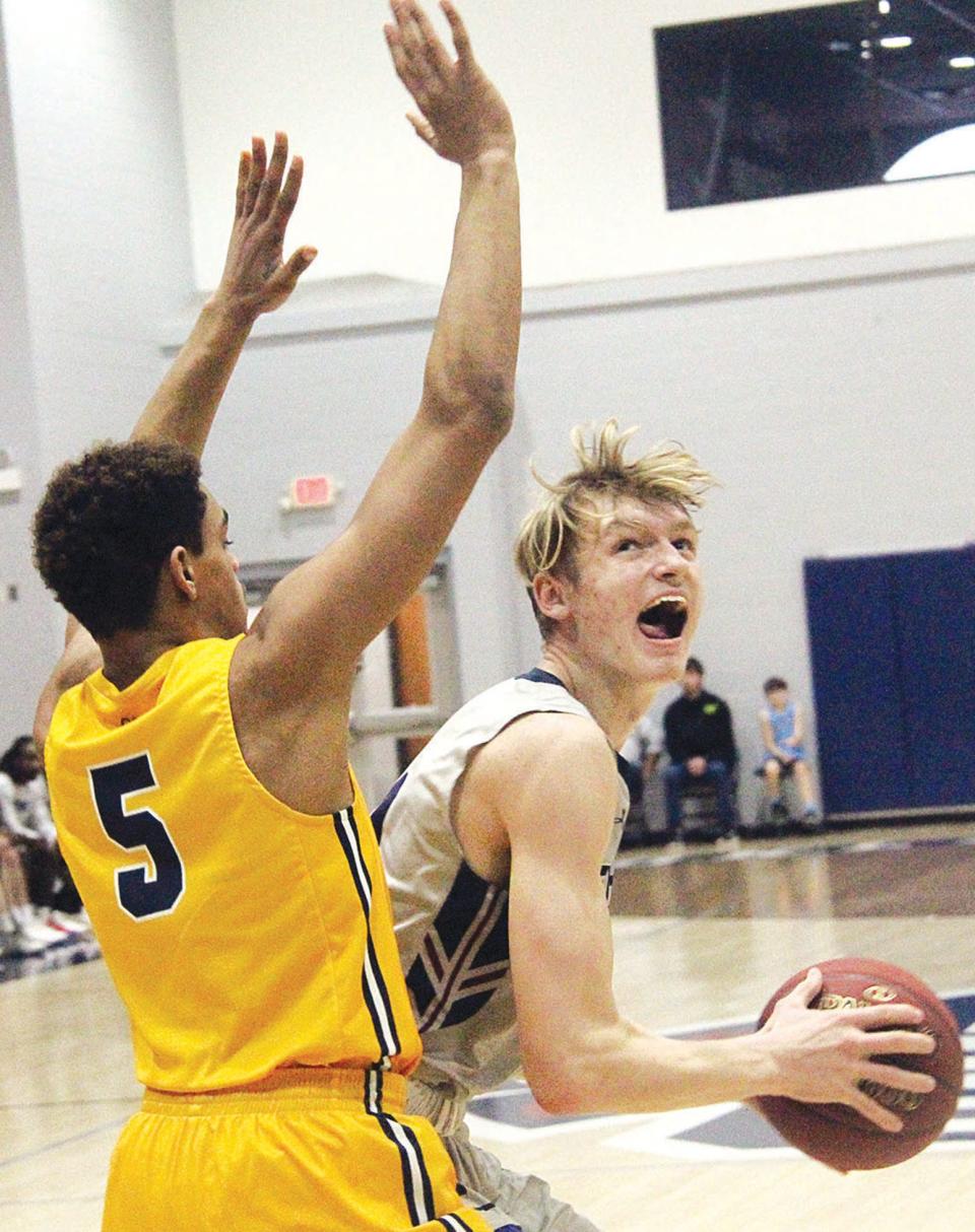 Oklahoma Wesleyan University's Kaleb Stokes, right, attacks the basket during men's basketball action last season. Stokes was the team's second-leading scorer.