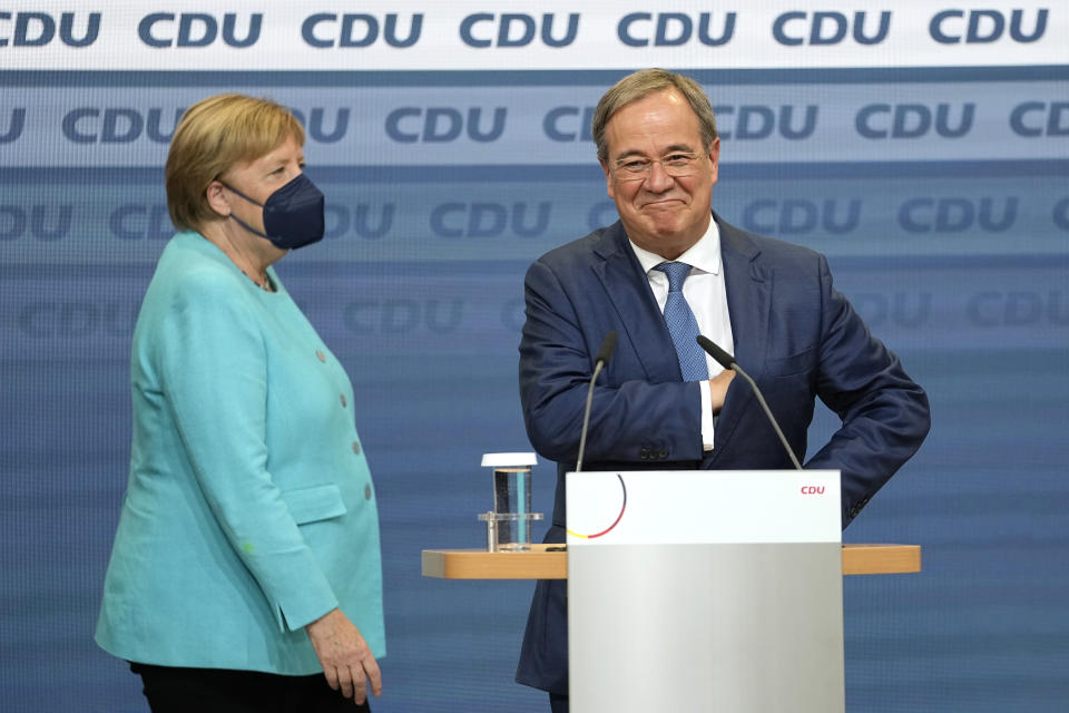 Chancellor Angela Merkel stands next to Governor Armin Laschet, right, the top CDU candidate after the German parliament elections at the Christian Democratic Union, CDU, party's headquarters in Berlin, Sunday, Sept. 26, 2021. German voters are choosing a new parliament in an election that will determine who succeeds Chancellor Angela Merkel after her 16 years at the helm of Europe's biggest economy. (AP Photo/Martin Meissner)