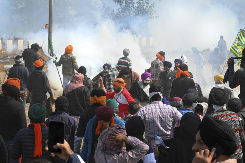 Protesting farmers are surrounded by tear gas near Shambhu border that divides northern Punjab and Haryana states, almost 200 km (125 miles) from New Delhi, India, Wednesday, Feb.14, 2024. Protesting Indian farmers Wednesday clashed with police for a second consecutive day as tens of thousands of them tried to march to the capital New Delhi to demand guaranteed crop prices for their produce. (AP Photo/Rajesh Sachar)