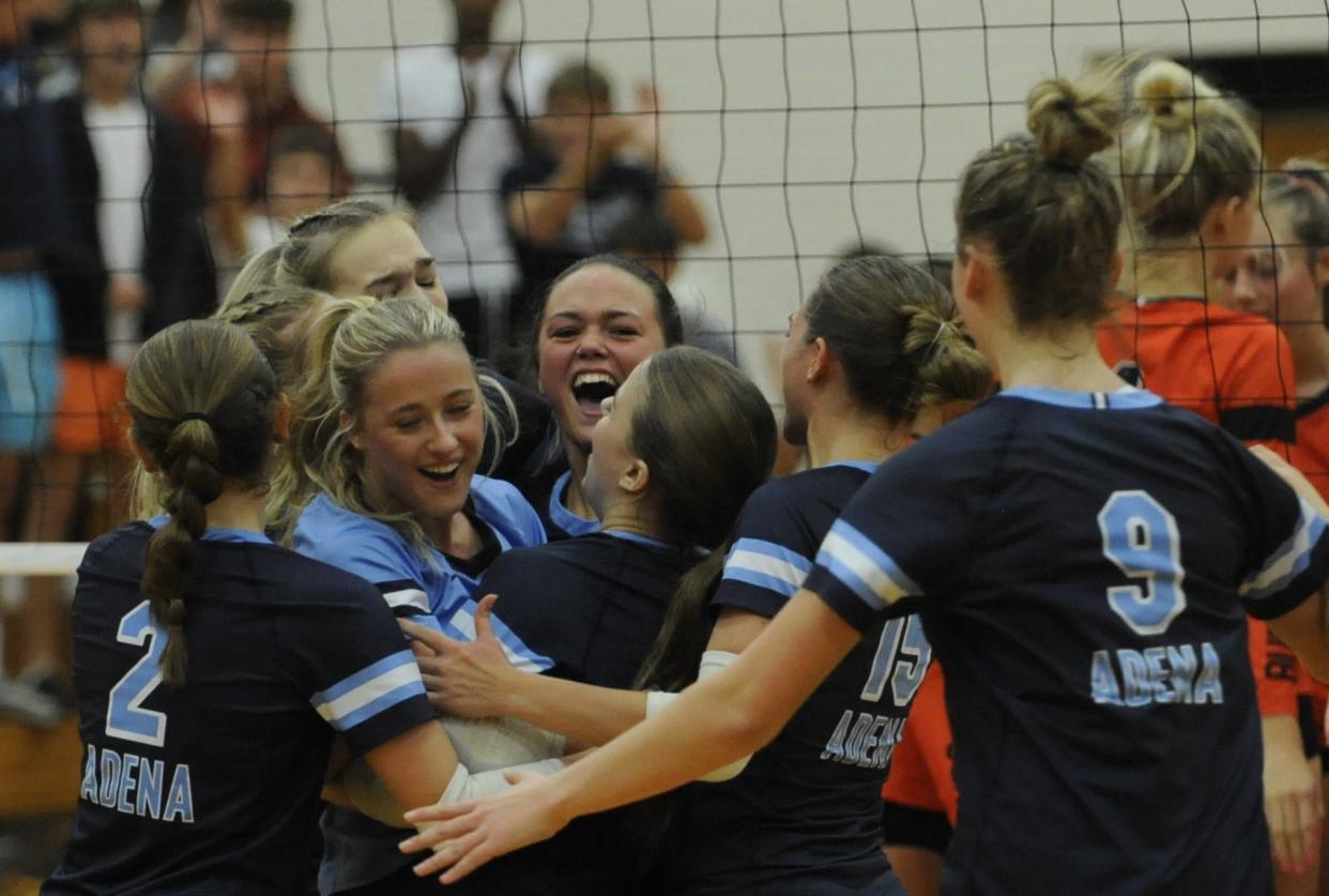 Adena's volleyball team embraces on the court at Waverly High School after sweeping the Wheelersburg Pirates in the Division III district finals on Oct. 28, 2023.