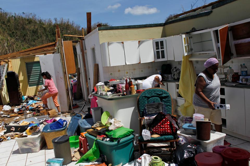 <p>Family members collect belongings after hurricane force winds destroyed their house in Toa Baja, west of San Juan, Puerto Rico, on Sept. 24, 2017 following the passage of Hurricane Maria.<br> Authorities in Puerto Rico rushed on September 23, 2017 to evacuate people living downriver from a dam said to be in danger of collapsing because of flooding from Hurricane Maria. (Photo: Ricardo Arduengo/AFP/Getty Images) </p>