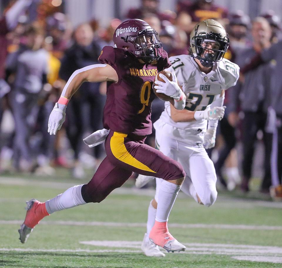 Walsh Jesuit's Aiden Henry returns a second quarter interception while being chased by St. Vincent-St. Mary's Blake Kane on Friday, Oct. 21, 2022 in Cuyahoga Falls.
