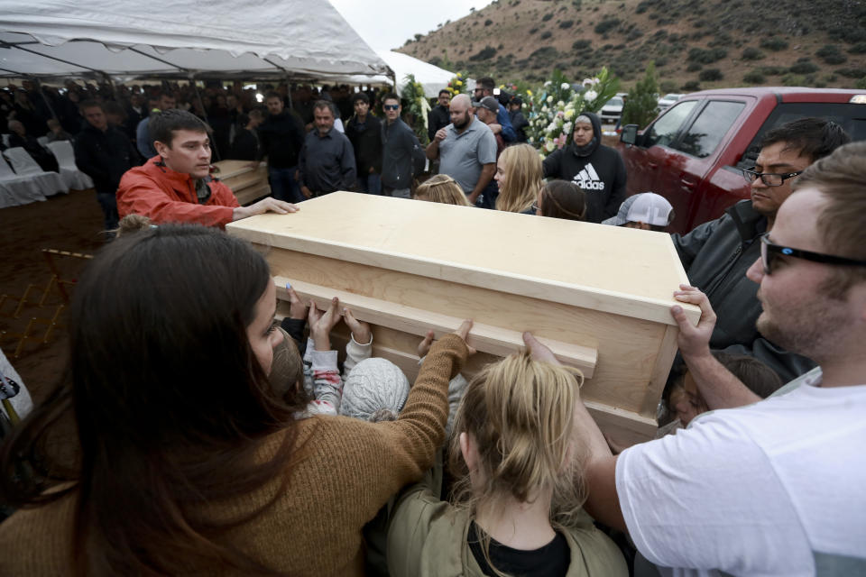 Family and friends unload the coffins that contain the remains of Rhonita Miller, and four of her young children Krystal and Howard, and twins Titus and Tiana, who were murdered by drug cartel gunmen earlier in the week, for a burial service at the cemetery in Colonia Le Baron, Mexico, Friday, Nov. 8, 2019. The bodies of Miller and four of her children were taken in a convoy of pickup trucks and SUVS, on the same dirt-and-rock mountainous road where they were killed Monday, for burial in the community of Colonia Le Baron in Chihuahua state. (AP Photo/Christian Chavez)