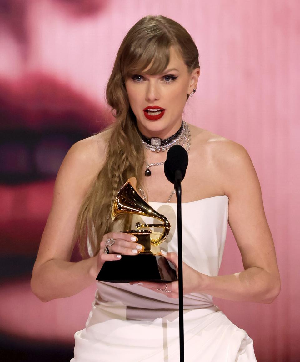 Taylor holding a Grammy award