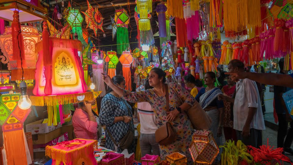 People in Mumbai look at lanterns at roadside stalls ahead of Diwali on November 5, 2023. - Rafiq Maqbool/AP