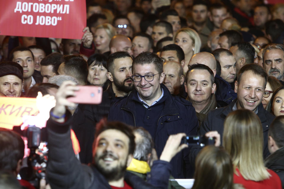 Hristijan Mickoski, center, the leader of the opposition conservative VMRO-DPMNE party, takes a part in a protest march starting outside the Public Prosecutor's office and ending in front of the complex of national courts, in Skopje, North Macedonia, Tuesday, Feb. 25, 2020. Thousands of conservative opposition party supporters were marching in North Macedonia's capital Skopje late on Tuesday, accusing the outgoing leftist government for strongly influencing prosecution and court decisions. (AP Photo/Boris Grdanoski)