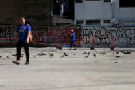 Women walk pass near pigeons on a street side in Bangkok, Thailand September 26, 2018. REUTERS/Soe Zeya Tun