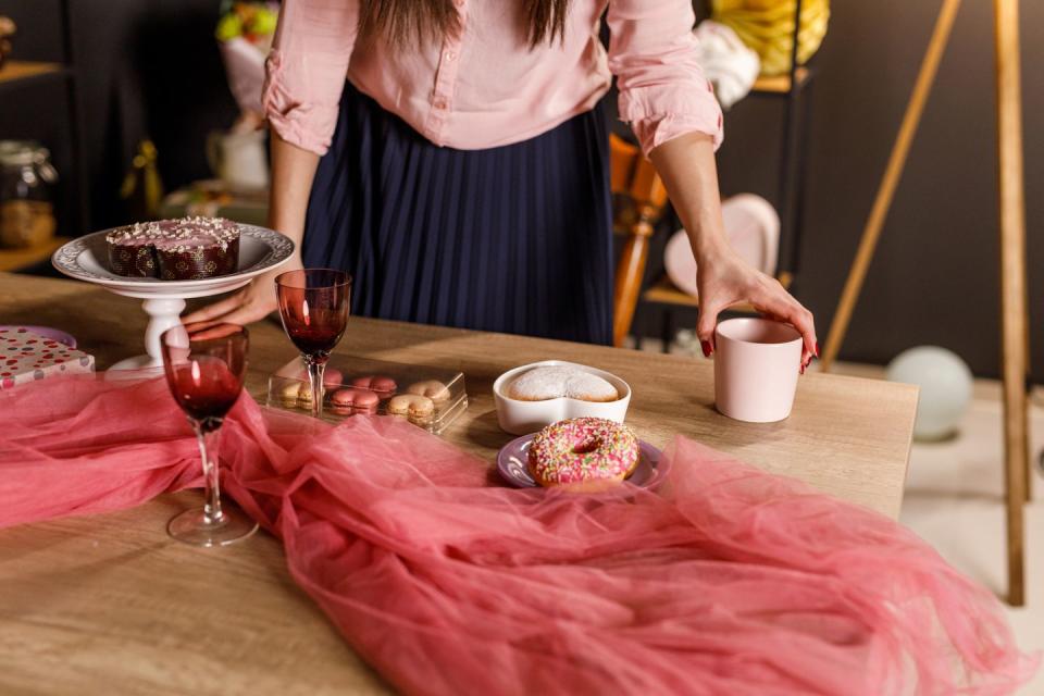 young woman setting up the table for valentine's day celebration