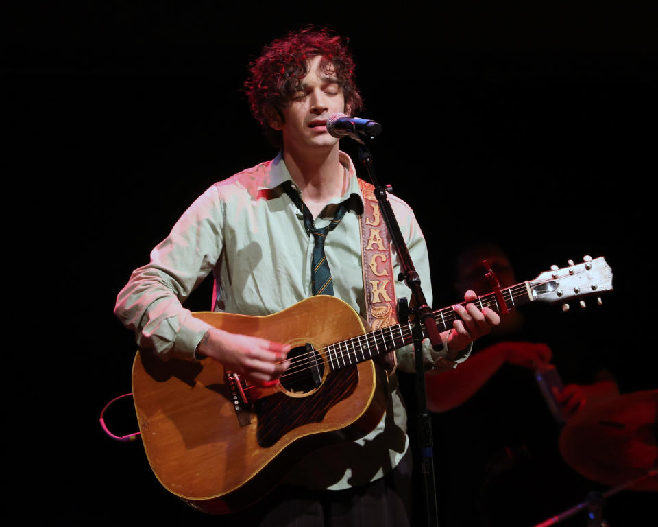 matty playing the guitar on stage